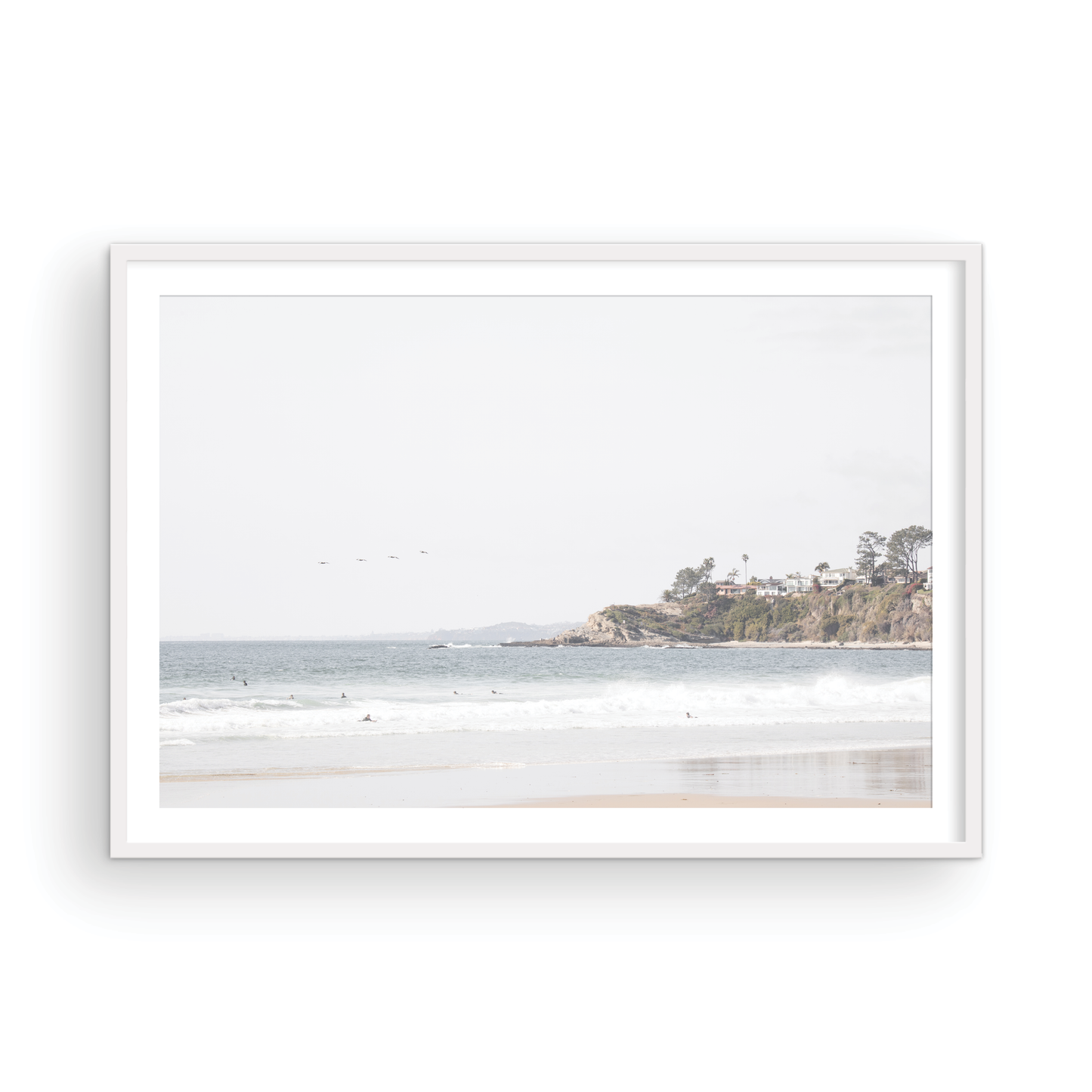 Landscape surf wall decor featuring surfers in the ocean near Salt Creek Beach, with a distant residential coastline and crashing waves. This print captures the surf vibes. Photograph in minimalist mock up.