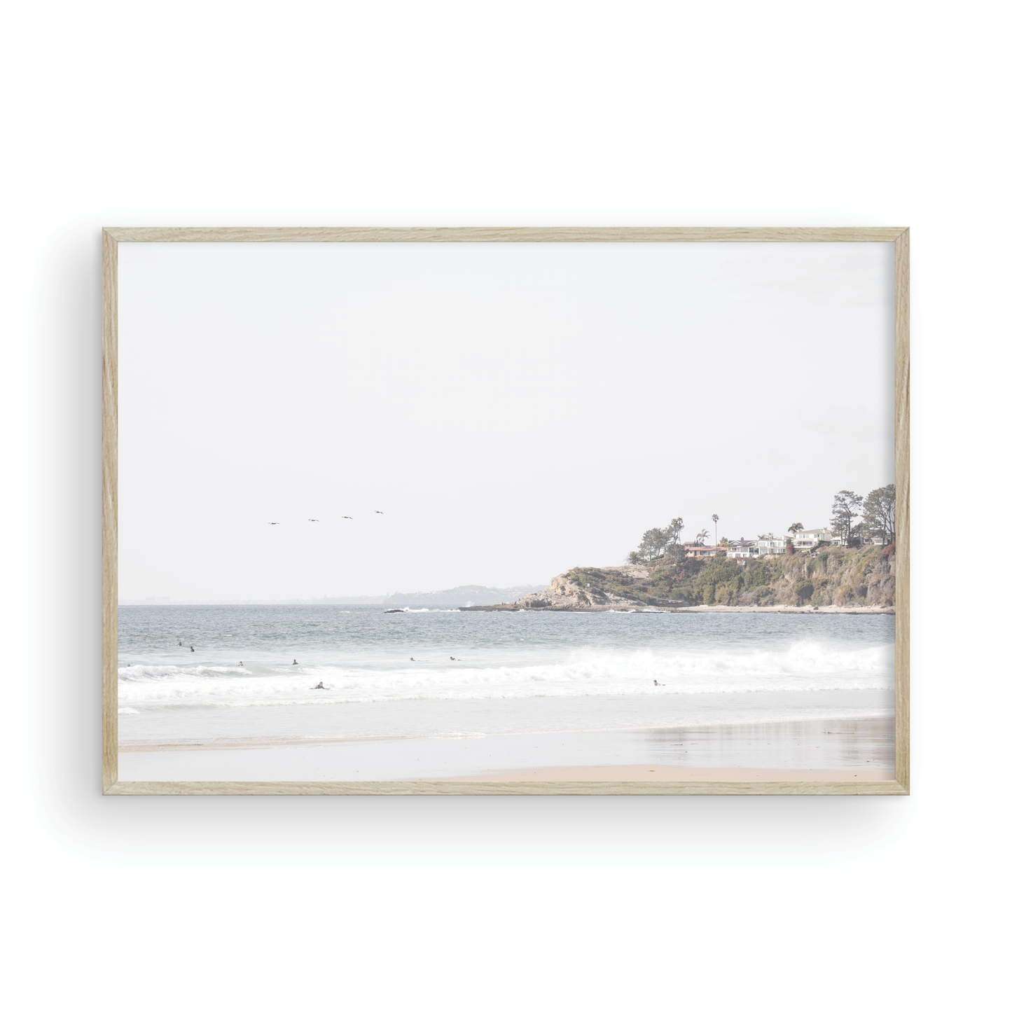 Landscape surf wall decor featuring surfers in the ocean near Salt Creek Beach, with a distant residential coastline and crashing waves. This print captures the surf vibes. Photograph in minimalist mock up.