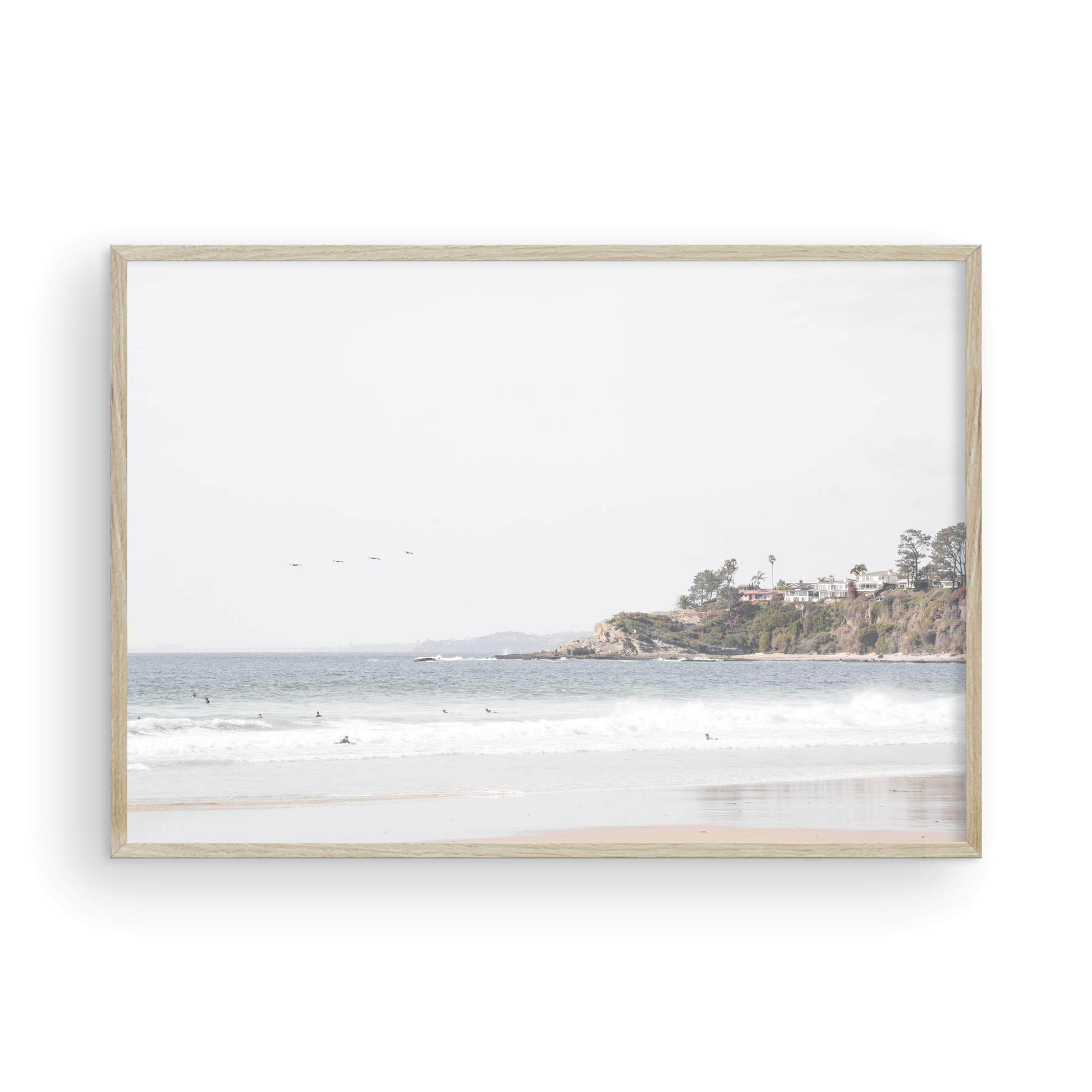 Landscape surf wall decor featuring surfers in the ocean near Salt Creek Beach, with a distant residential coastline and crashing waves. This print captures the surf vibes. Photograph in minimalist mock up.