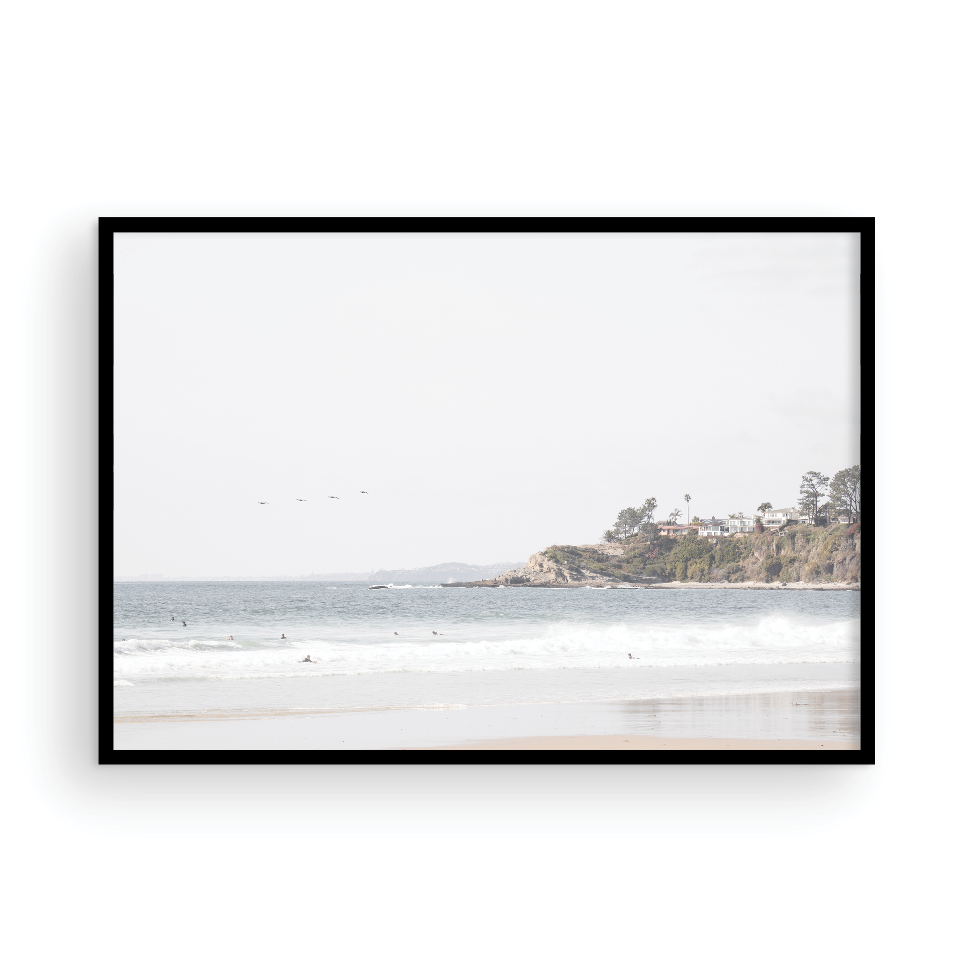 Landscape surf wall decor featuring surfers in the ocean near Salt Creek Beach, with a distant residential coastline and crashing waves. This print captures the surf vibes. Photograph in minimalist mock up.
