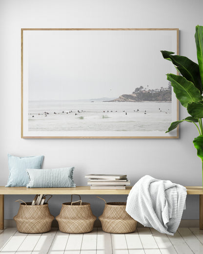 Landscape surf wall decor showing many surfers waiting for waves in the ocean at Salt Creek Beach, with a distant cliffside. This print captures the surf vibes of Southern California. Photograph in minimalist mock up.