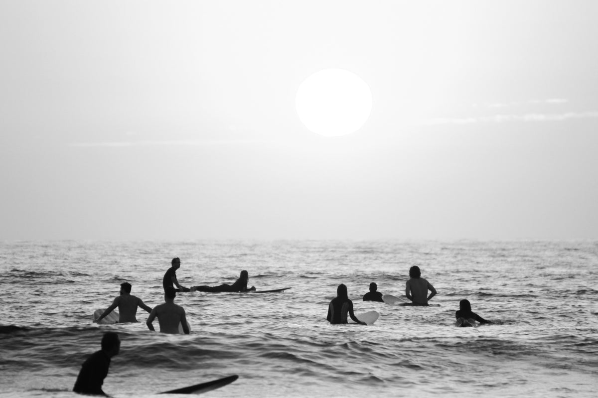 Surfers in the water at Beacons Beach, Encinitas California at sunset, in black and white, by Salt Creek Prints