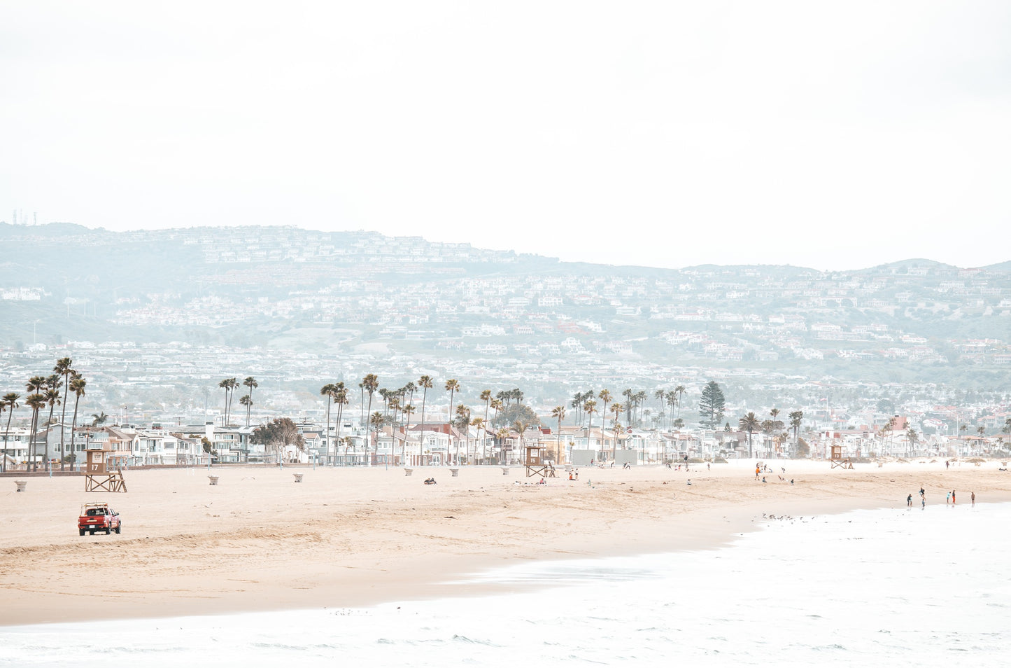 Photography by Kim Dybczak of: California lifeguard tower stands near the shoreline, framed by sand and quiet surf.