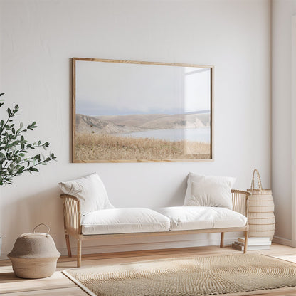 Framed photo of: Drakes Bay 7299 displayed above a couch in a neutral room.