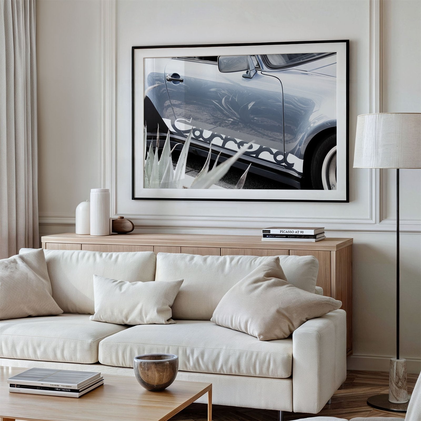 Framed photo of: Porsche Carrera 8334 displayed on a wall above a couch in a neutral living room.