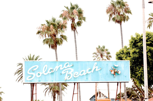 Photography by Kim Dybczak of: Retro Solana Beach sign in light blue, captured as colorful travel photography.