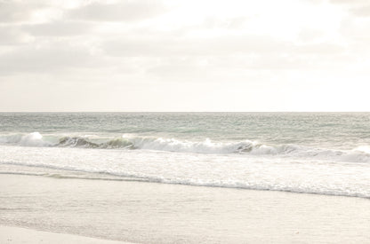 Photography by Kim Dybczak of: San Diego coast settles into long bands of sand and water beneath open sky.
