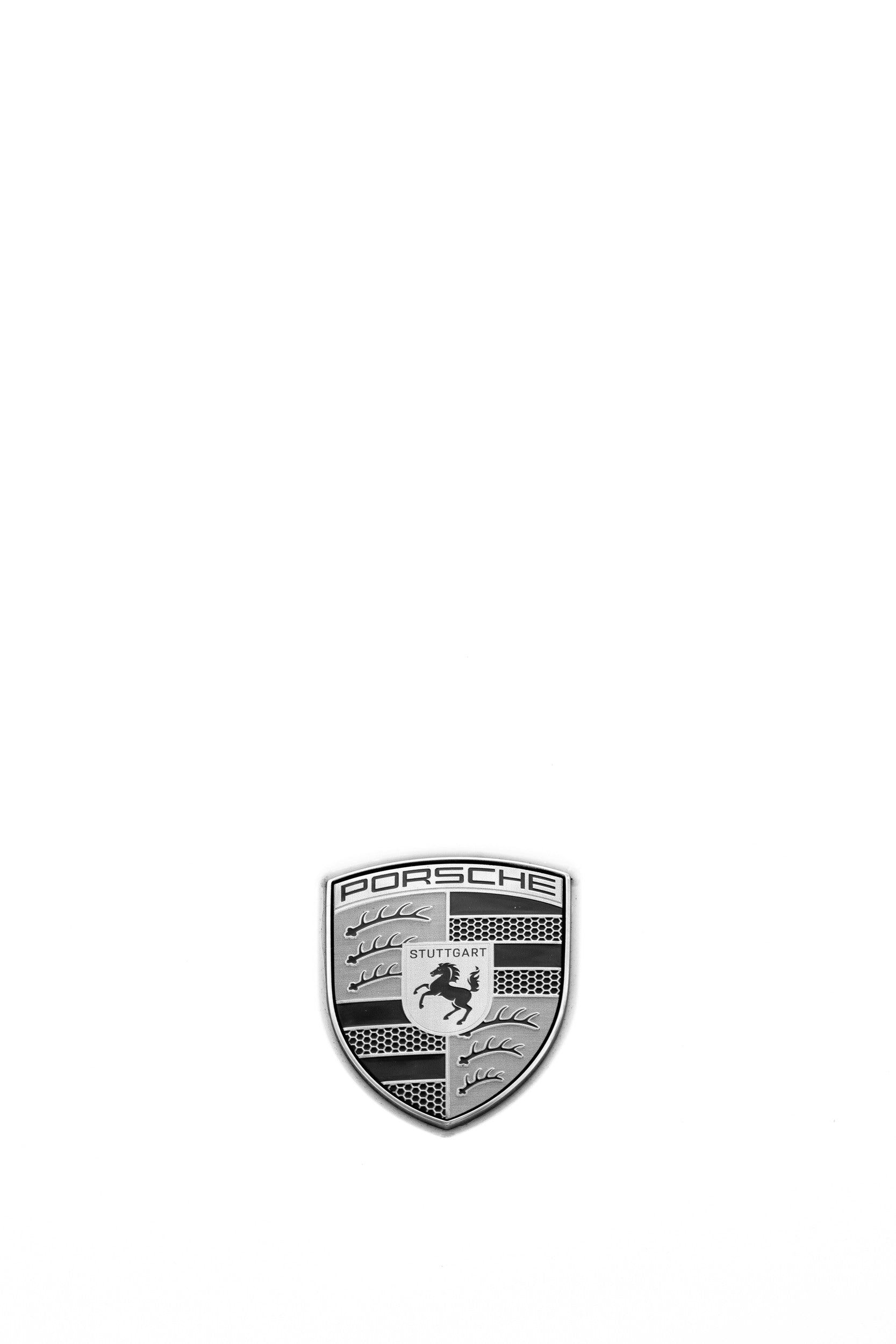Photography by Salt Creek Prints of: Porsche 8364, Close up black and white image of the Porsche logo from a classic white Porsche.