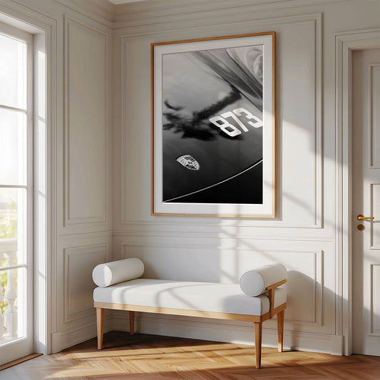 Framed photo of: Porsche 8312 displayed above a bench in a luxury hallway. 
