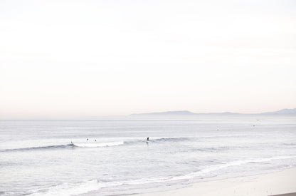 Photography by Kim Dybczak of: A calm beach scene opens into soft surf and a distant horizon.