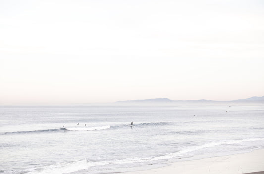Photography by Kim Dybczak of: A calm beach scene opens into soft surf and a distant horizon.