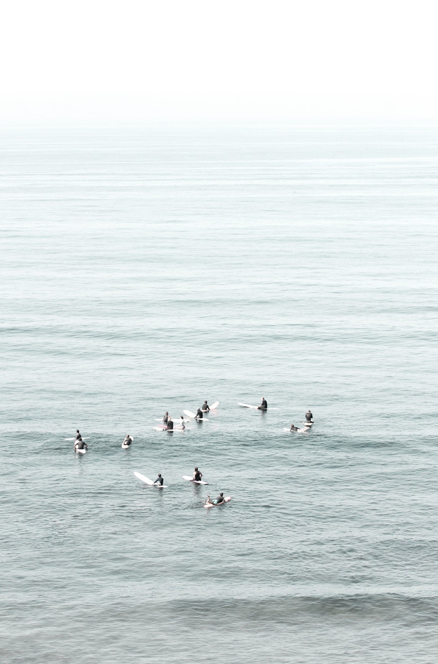Photography by Kim Dybczak of: Surfers wait beyond the break at California, watching sets roll in toward shore.
