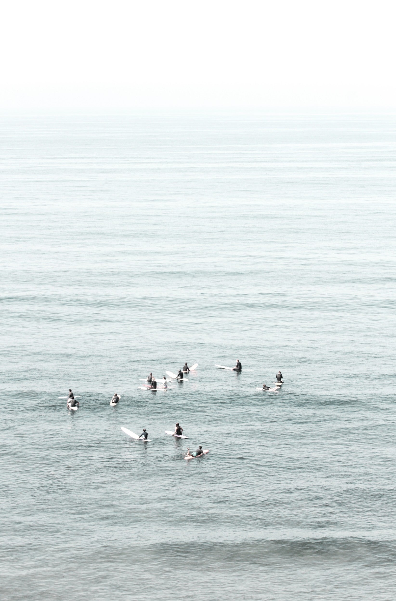 Photography by Kim Dybczak of: Surfers wait beyond the break at California, watching sets roll in toward shore.