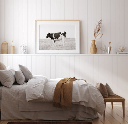 Framed photo of: Cow 7197 above a bed in a farmhouse bedroom.