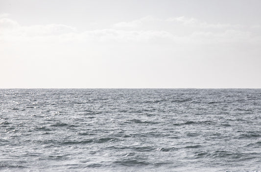 Photography by Kim Dybczak of: San Diego coast settles into long bands of sand and water beneath open sky.