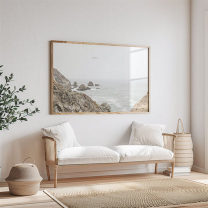 Framed photo of: Bodega Head 7714 displayed above a couch in a neutral room.