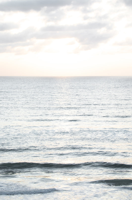 Photography by Kim Dybczak of: Soft blue waves and pale clouds form a calm Southern California seascape.