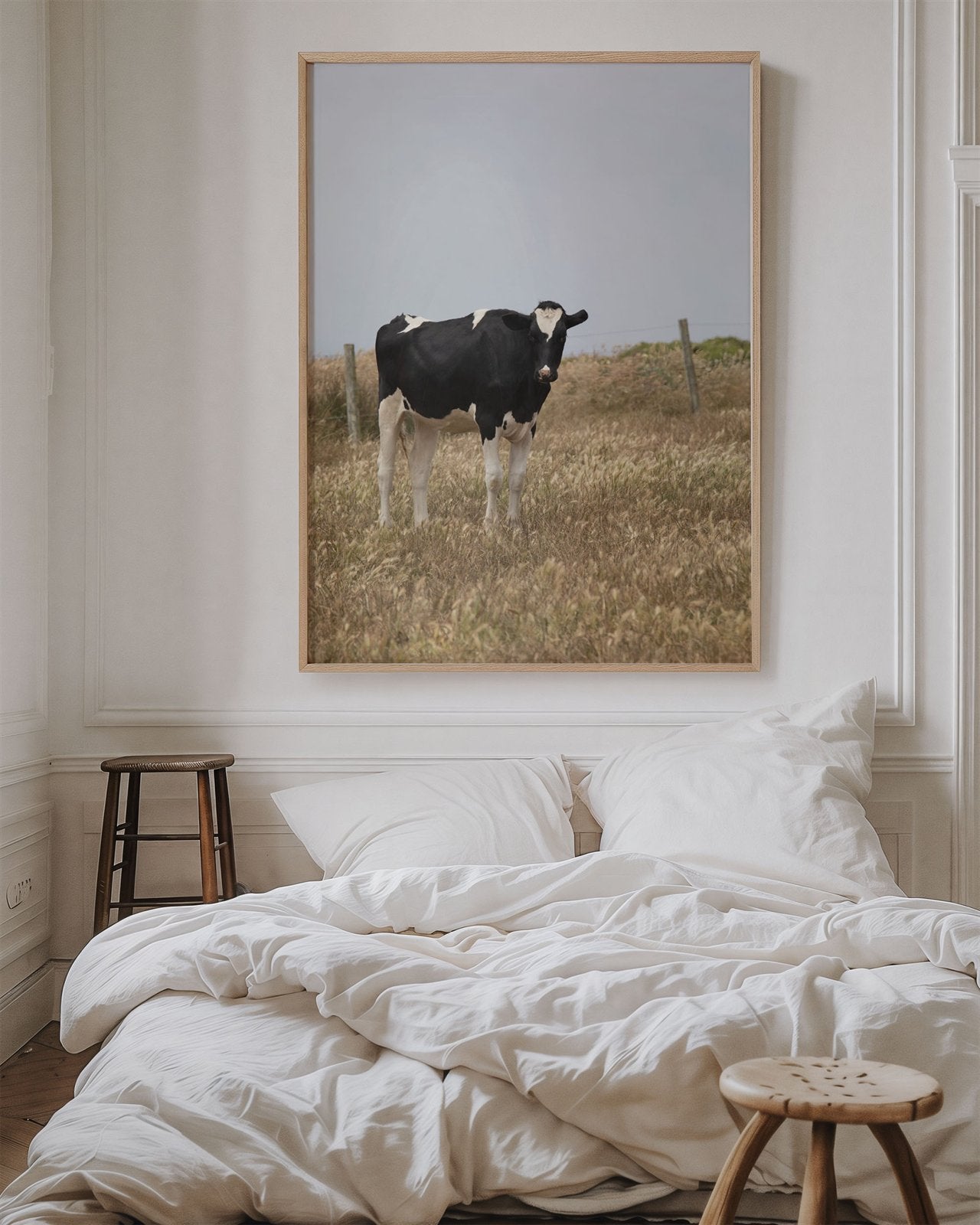 Oversized framed photo of: Cow 7204 displayed on a wall above a cozy white bed.