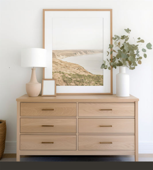 Framed photo of: Drakes Bay 7273 displayed on a modern dresser. 