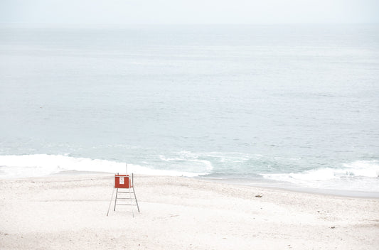 Photography by Kim Dybczak of: A lifeguard tower anchors Laguna, set against calm water and open sky.