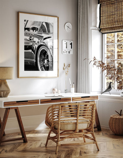 Framed photo of: Porsche 8346 displayed on a wall above a desk.