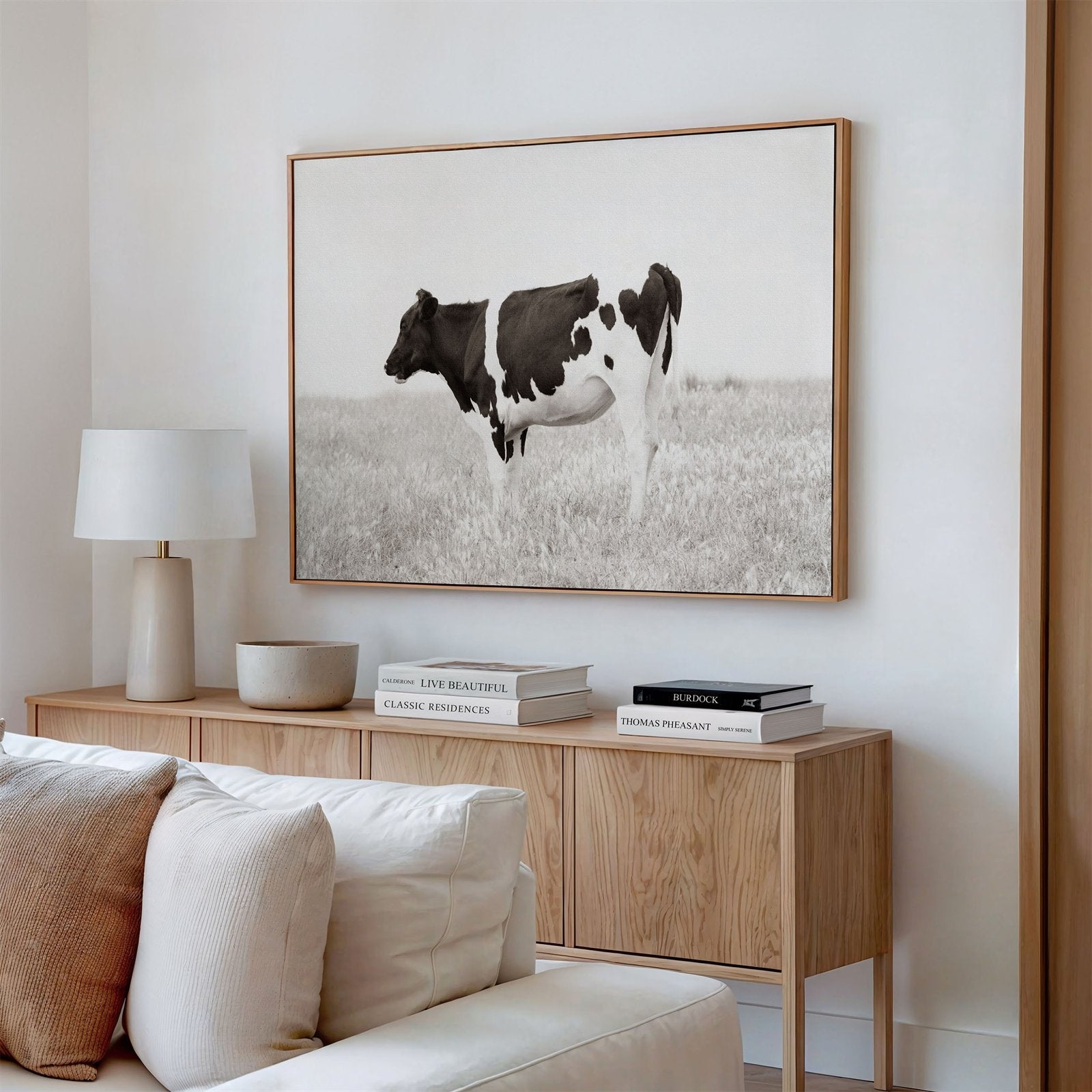 Framed canvas photo of: Cow 7197 displayed on a wall above a console in a neutral modern living room.