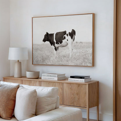 Framed canvas photo of: Cow 7197 displayed on a wall above a console in a neutral modern living room.