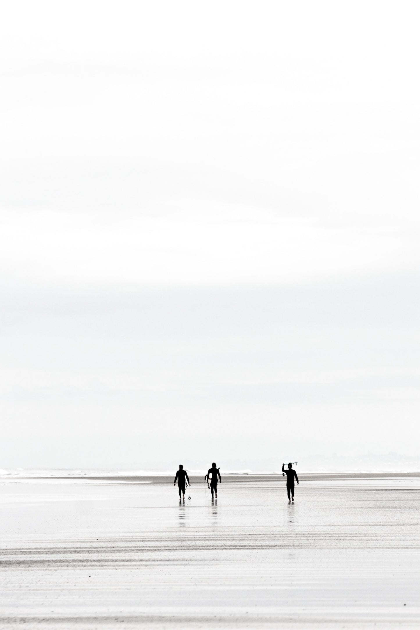 Surfers carrying surfboards on the sand at Black’s Beach, black and white, by Salt Creek Prints