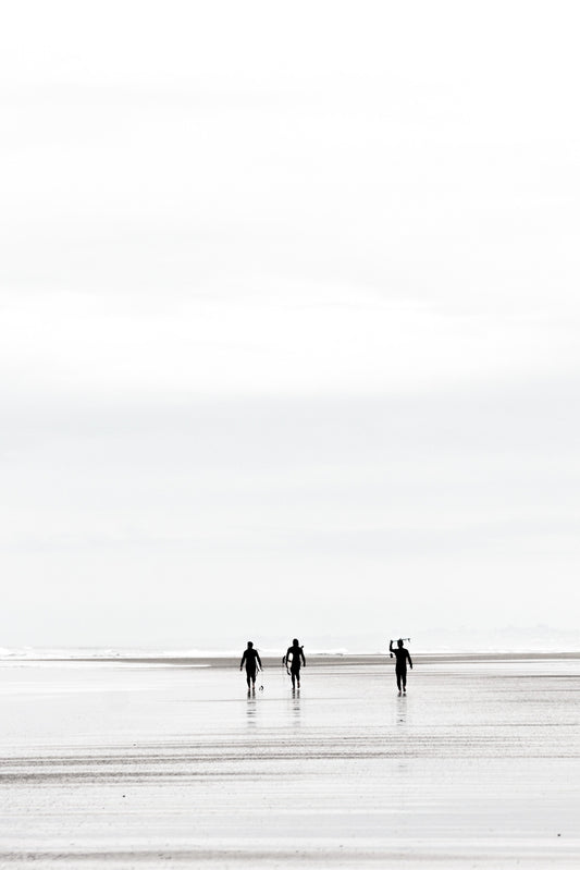 Surfers carrying surfboards on the sand at Black’s Beach, black and white, by Salt Creek Prints