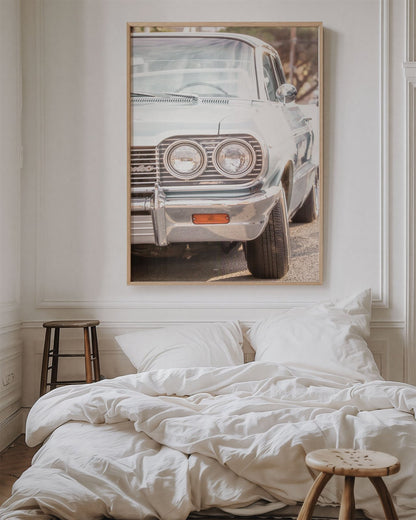 Framed photo of: Chevrolet 7975 displayed on a wall above a bed in a cozy bedroom.