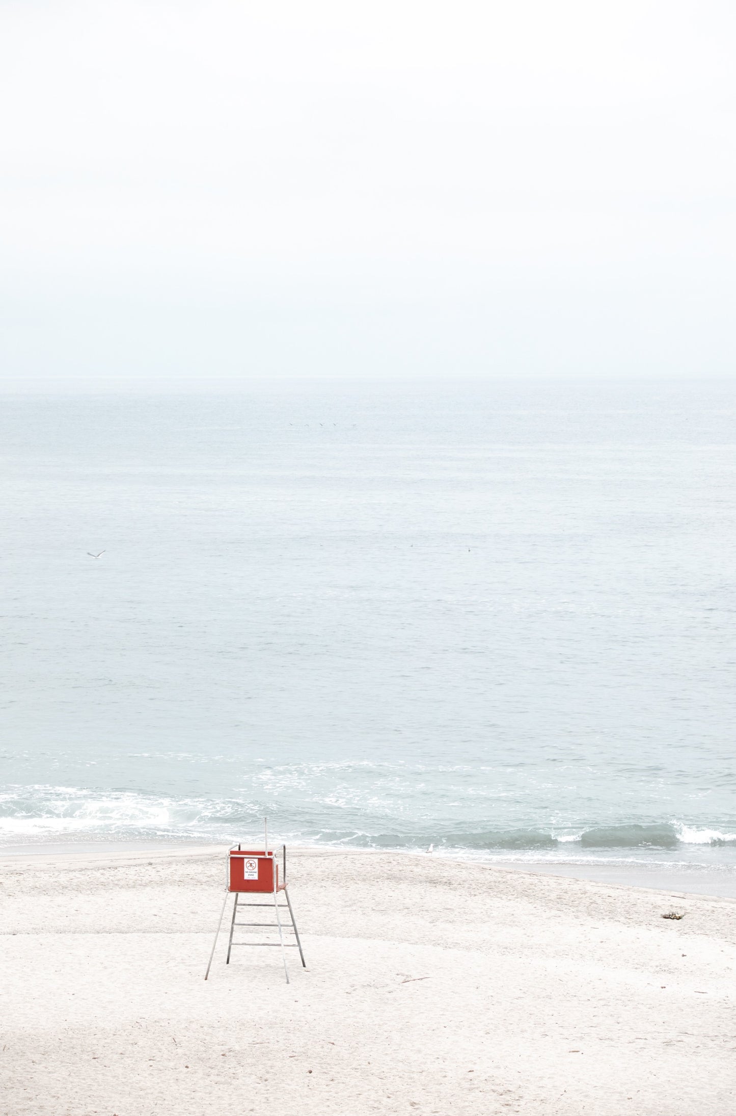 Photography by Kim Dybczak of: Laguna lifeguard tower stands near the shoreline, framed by sand and quiet surf.