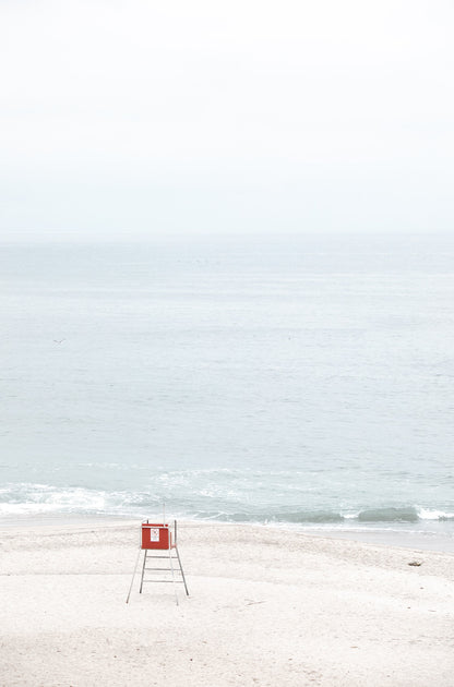 Photography by Kim Dybczak of: Laguna lifeguard tower stands near the shoreline, framed by sand and quiet surf.