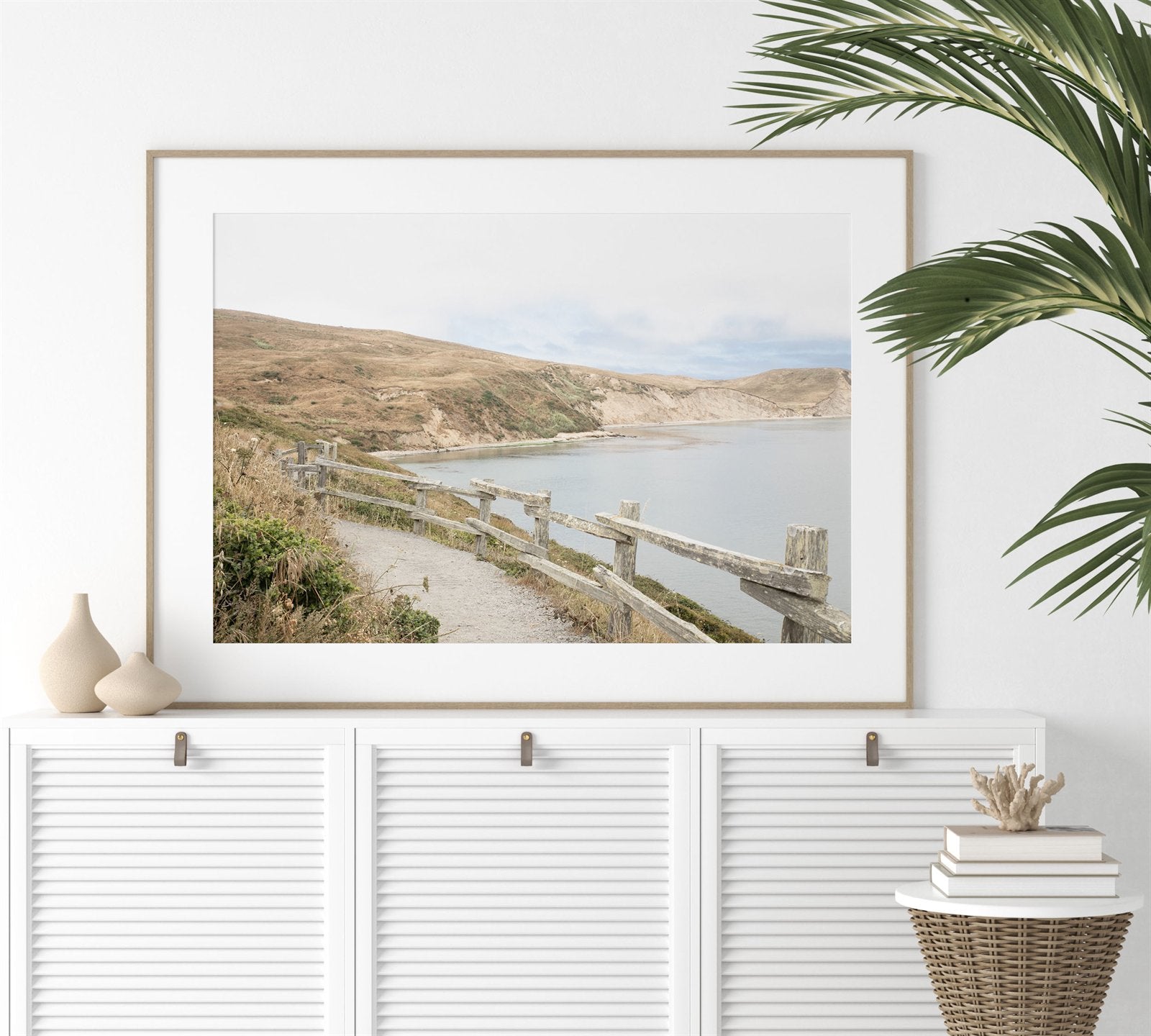 Framed photo of: Drakes Bay 7372 displayed above a white console.