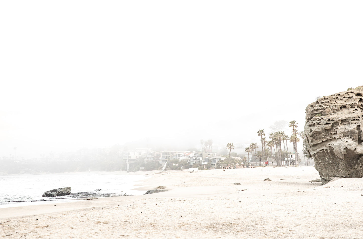 Photography by Kim Dybczak of: Laguna shoreline with gentle waves smoothing the sand, softened by coastal haze.
