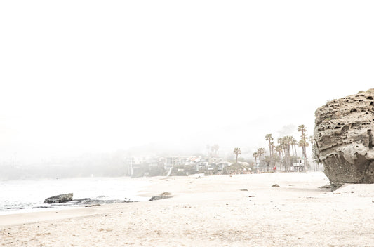 Photography by Kim Dybczak of: Laguna shoreline with gentle waves smoothing the sand, softened by coastal haze.