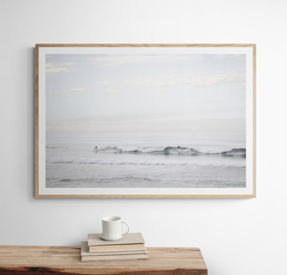Horizontal minimalist ocean art with a close-up blue waves print of water, featuring subtle ripples and soft textures, ideal as a neutral ocean print, surfers in the waves. Photograph in minimalist mock up.
