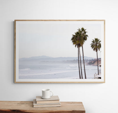 Landscape San Diego beach print showing a seascape with gentle ocean waves in the water and palm trees in the foreground. Photograph in minimalist mock up.