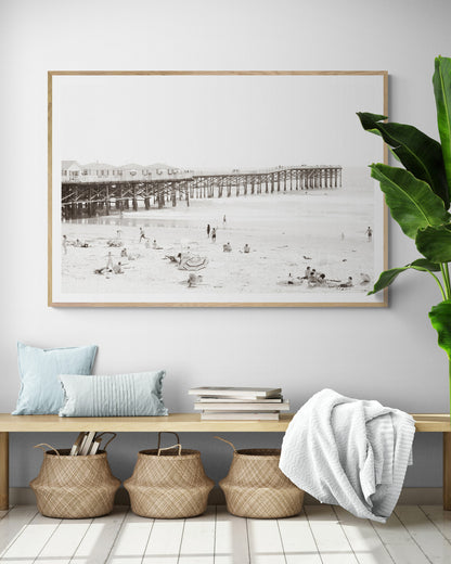 Sepia beach photo of Crystal Pier in Pacific Beach, San Diego, with people on the sandy beach. This framed coastal print showcases iconic beach scenes. Photograph in minimalist mock up.